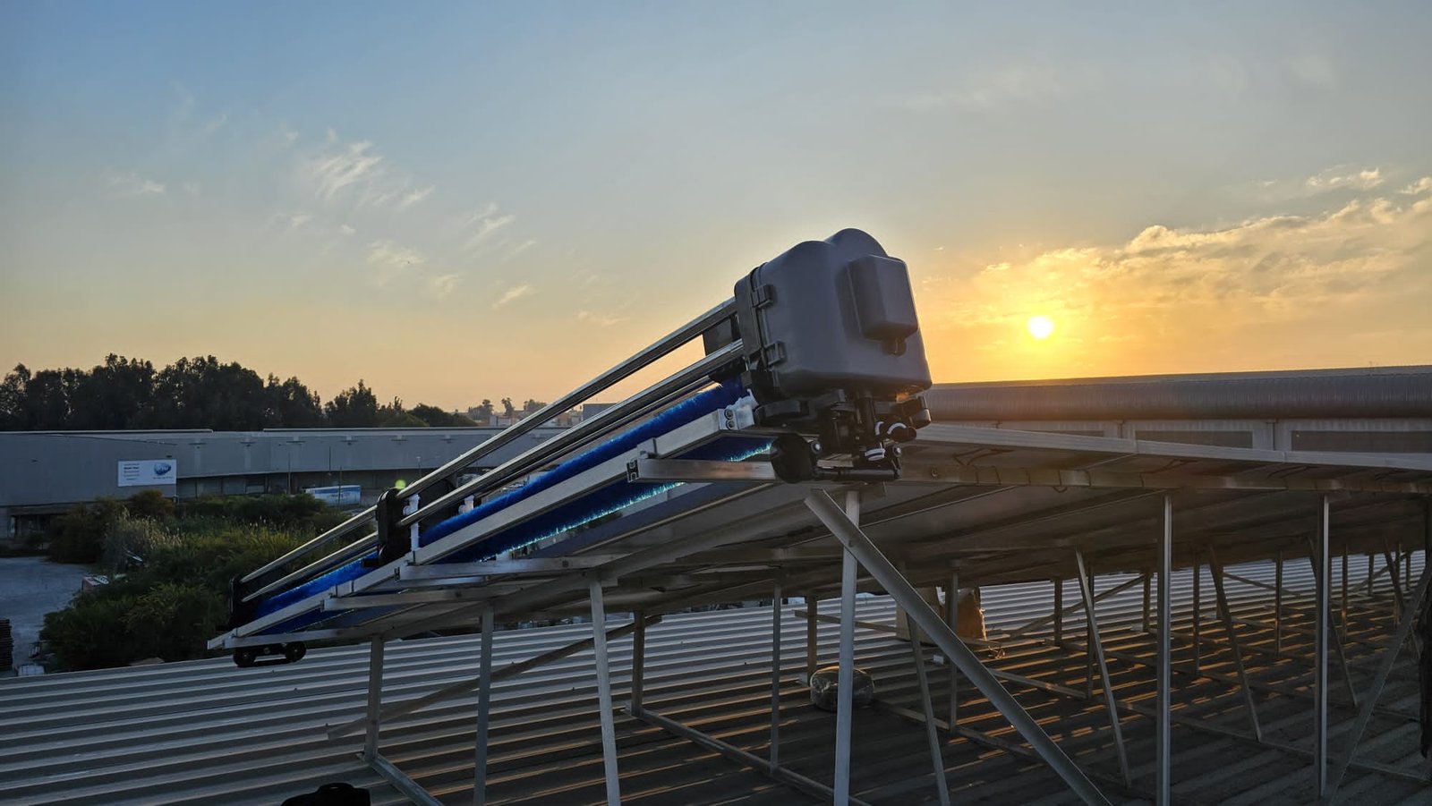 Autonomous cleaning equipment operating across rows of solar panels in a large solar power plant.