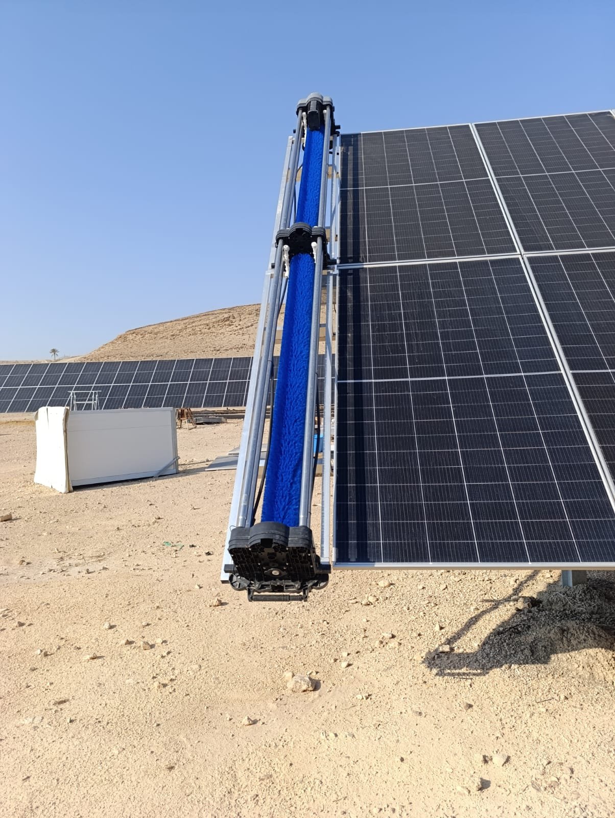 Water-powered autonomous cleaning robot moving across solar panels without electrical rails or batteries.